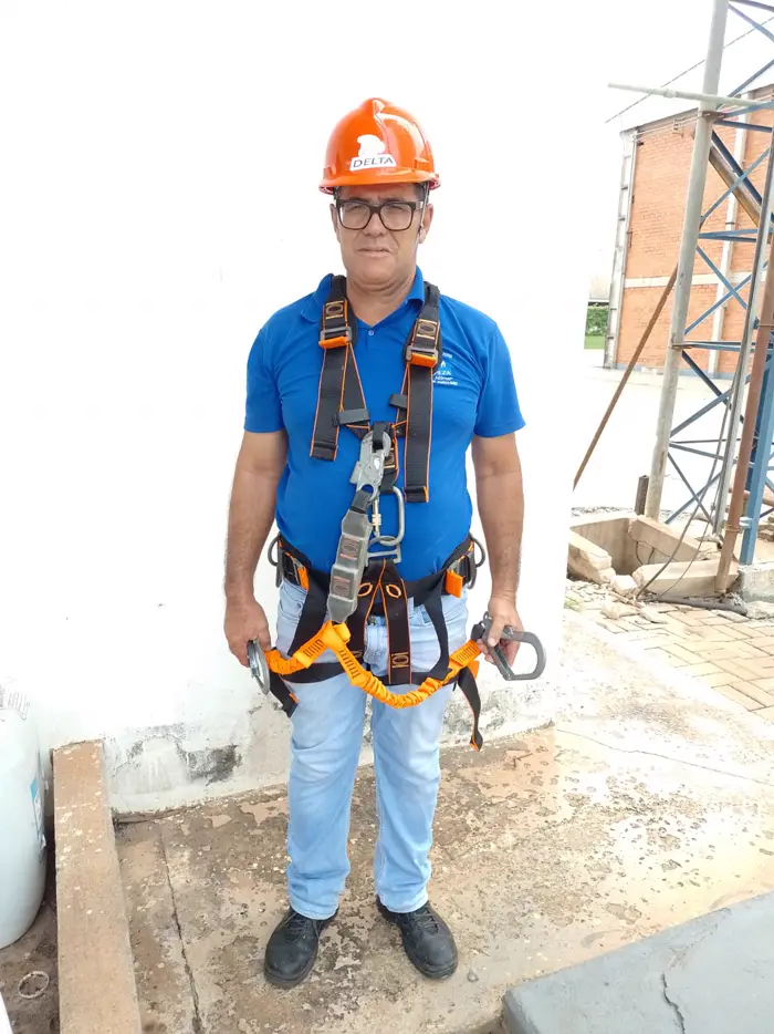 Técnico da El Shaday Dedetizadora com capacete e cinto de segurança para limpeza de caixa d'água